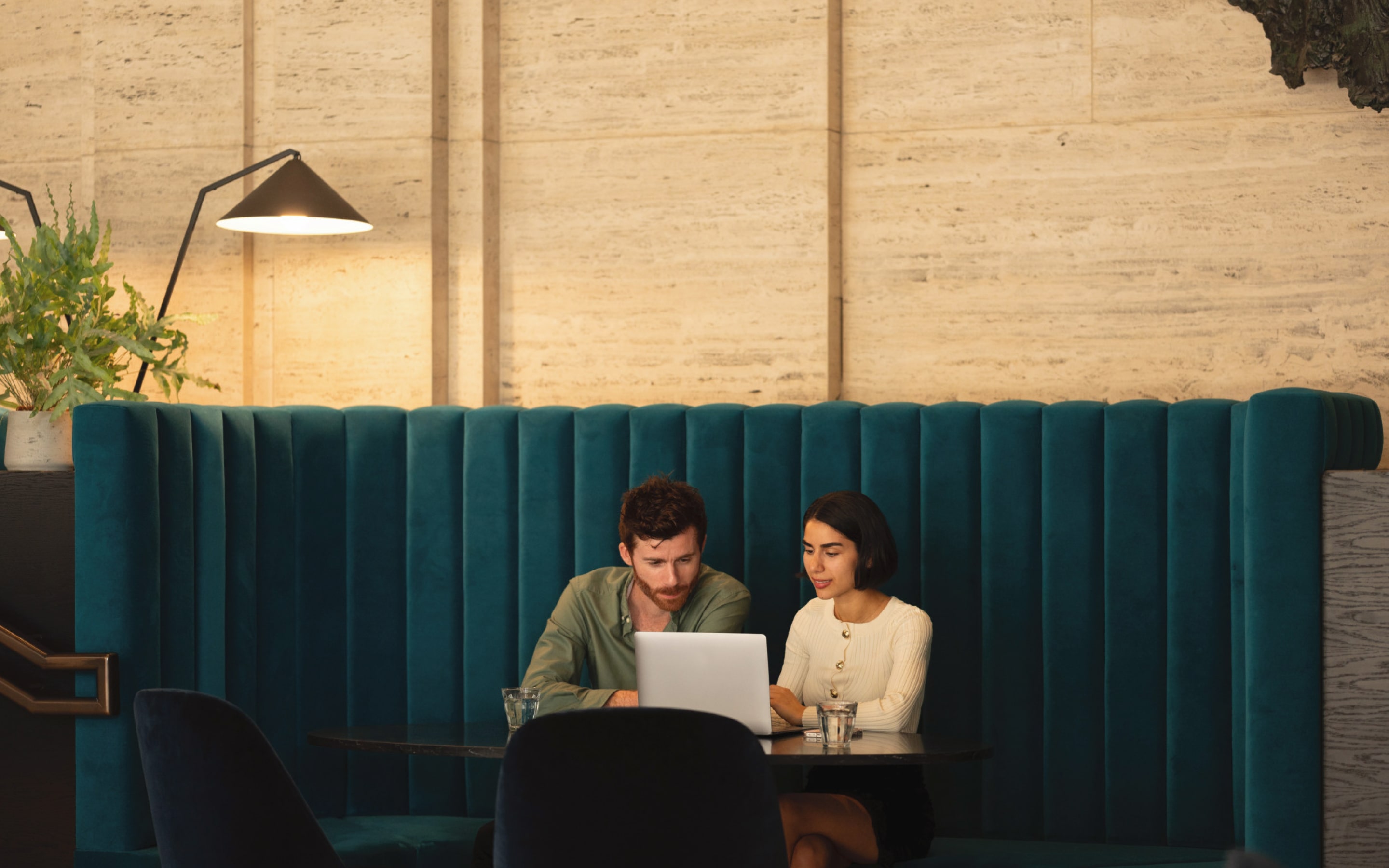 Two people chatting next to a laptop